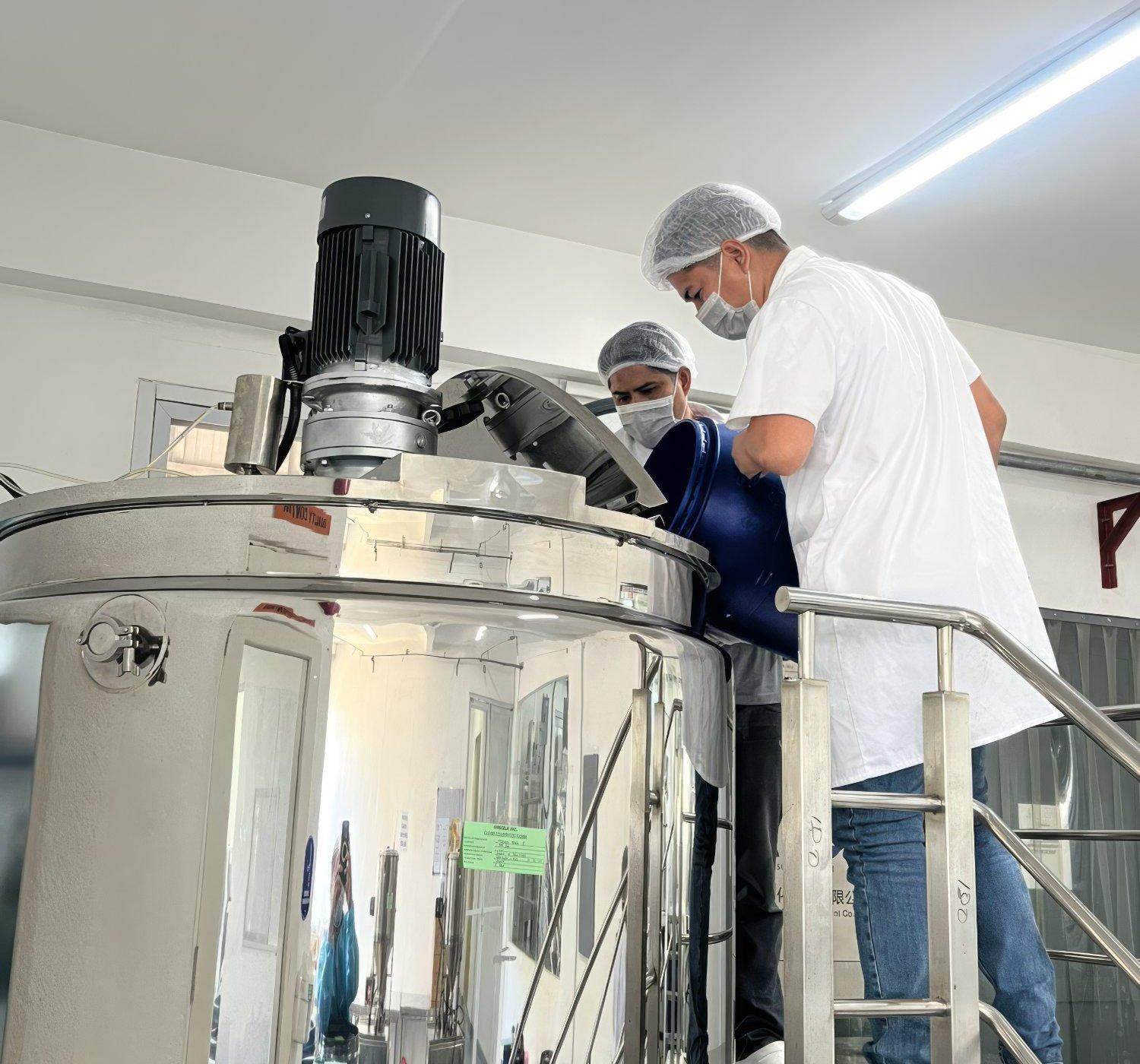Orsolab employees working at stainless steel mixing tank in FDA-licensed manufacturing facility Philippines